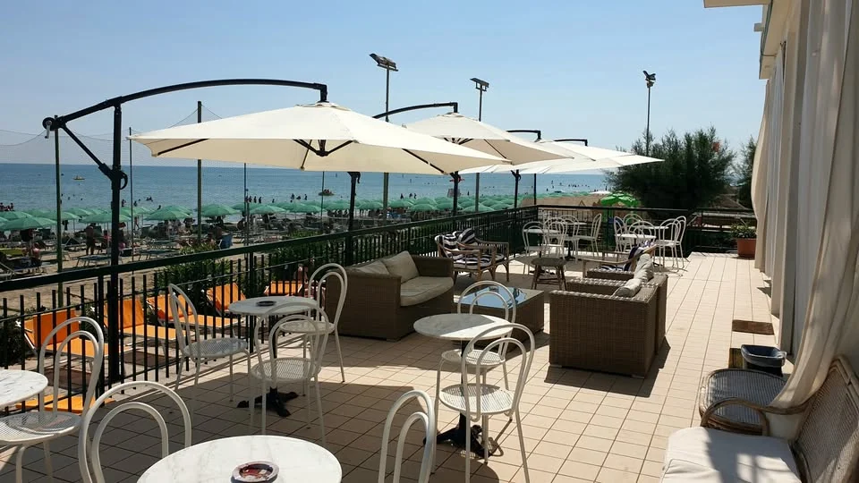 La terrazza dell’hotel con tavolini e ombrelloni affacciati sul mare